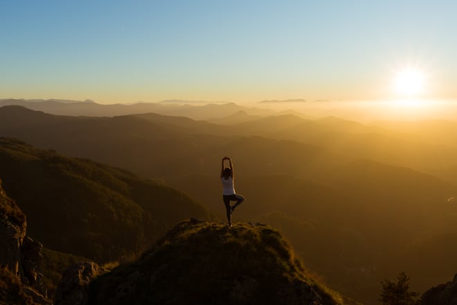 Person macht Yoga auf dem Berg